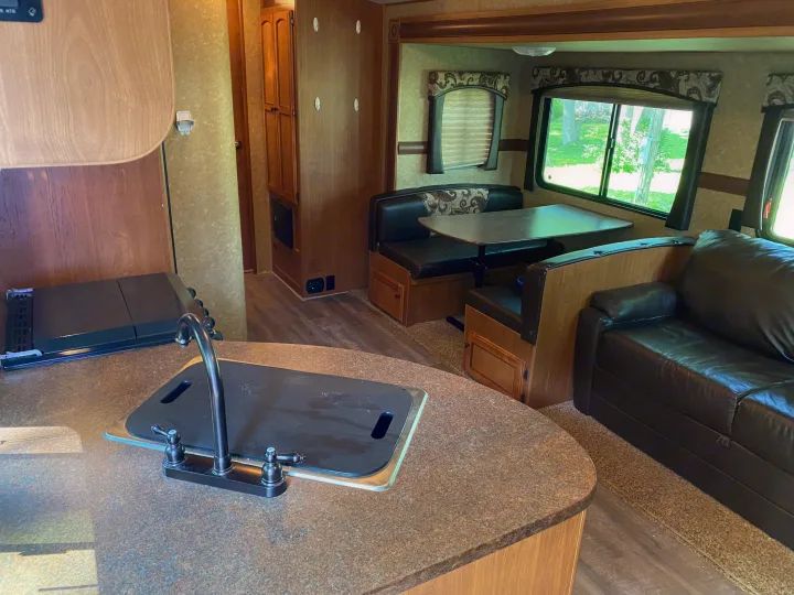 Comfortable RV rental interior with a kitchen, dinette, and sofa, perfect for your next road trip adventure.. Crossroads RV Sunset Trail Super Lite 2012