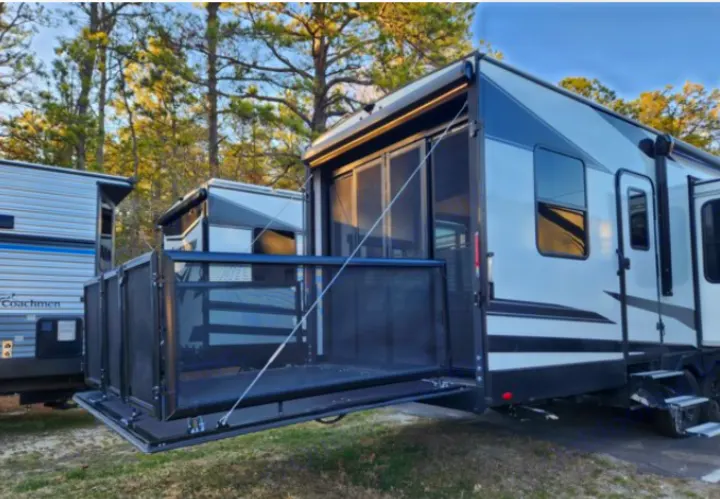 Toy hauler RV rental: Rear ramp converts to an outdoor patio with screens, ideal for campsite living.. Grand Design Momentum 2021