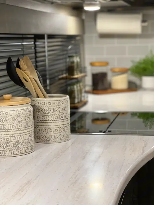 Modern RV rental kitchen with patterned utensil holders, a sleek countertop, and organized essentials for on-the-go cooking.. Grand Design Reflection 2021