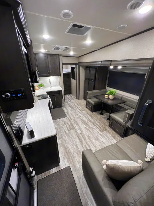 This modern RV rental features a well-appointed interior with a spacious kitchen, dining area, and comfortable living space.. Grand Design Reflection 2021