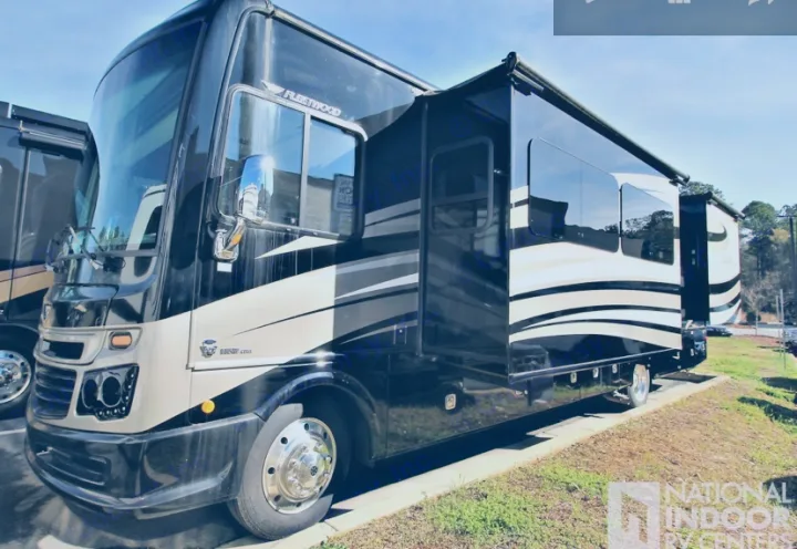 A large, two-tone black and beige Fleetwood motorhome, available for rv rental, is parked outside with its side awning extended.. Fleetwood Bounder 2017