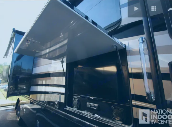 Experience premium RV rental: sleek motorhome with side compartment open revealing an outdoor TV & stereo system.. Fleetwood Bounder 2017