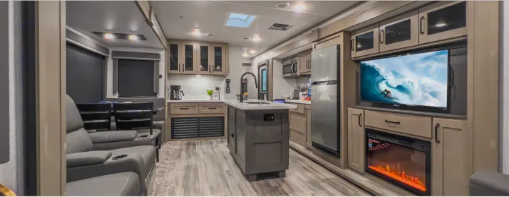 Modern RV rental interior showcasing a spacious living area, full kitchen, and entertainment center with a fireplace.. Grand Design Reflection 2022