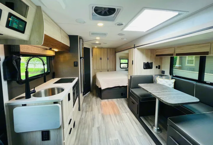 Well-designed RV rental interior showcasing a compact kitchen, comfortable dinette, and cozy bedroom for mobile adventures.. Forest River Forester 2401B 2023