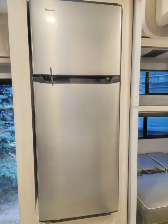 Stainless steel two-door RV rental refrigerator, equipped with a travel latch for secure storage during transit.. Forester LE 2022