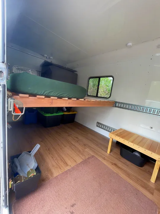 Spacious RV rental interior featuring a wooden bed platform with storage underneath, a window, and wood laminate flooring.. Weeroll Silver cloud 2020