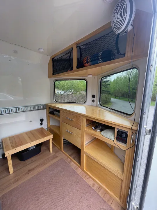 Inside a custom RV rental: light wood cabinetry, dual windows with scenic views, and smart storage for travel comfort.. Weeroll Silver cloud 2020