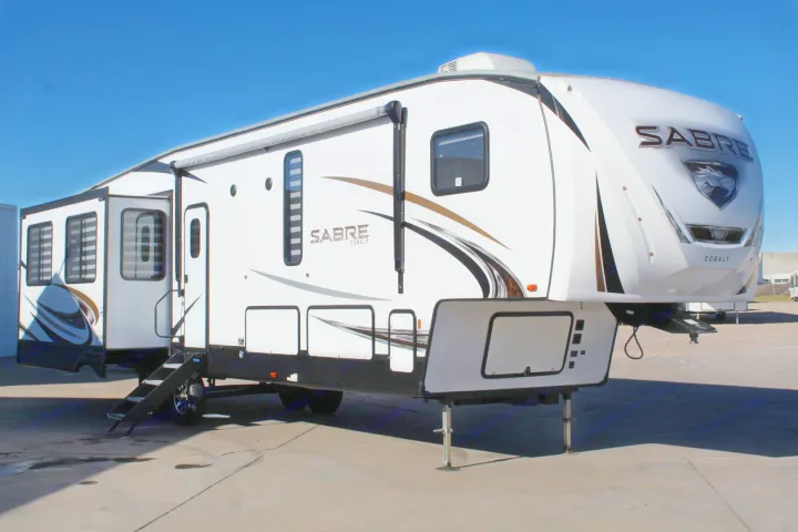 Large white Sabre Cobalt recreational vehicle (RV) with awning & slide-outs, perfect for an rv rental adventure.. Forest River Sabre 2021