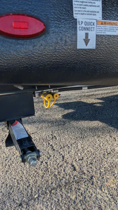Detail of an RV rental: LP quick connect for propane alongside a stabilizer jack stabilizing the travel trailer.. Forest River Palomino Puma XLE 2022