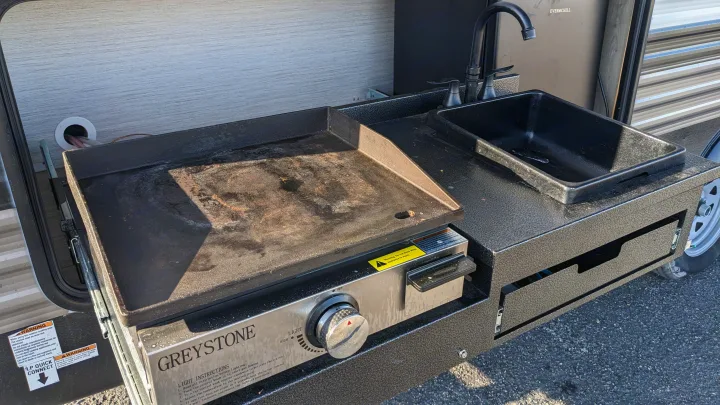 RV rental outdoor kitchen: flat-top griddle, sink, faucet for easy camping cooking & cleanup.. Forest River Palomino Puma XLE 2022