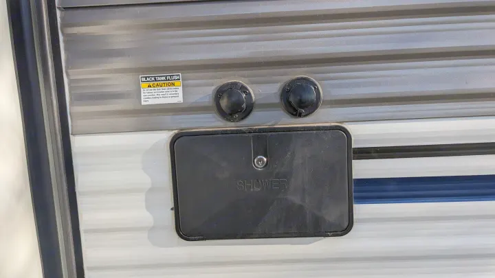 RV rental exterior: black tank flush inlets & outdoor shower port for essential utility hookups.. Forest River Palomino Puma XLE 2022