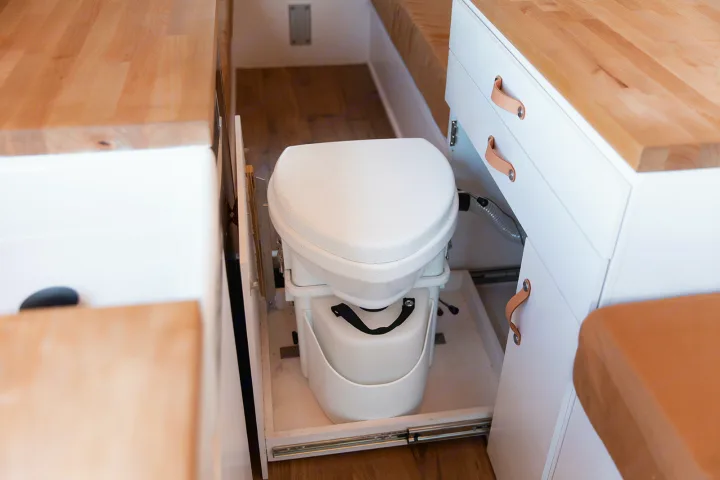 RV rental space-saver: a convenient pull-out toilet, integrated within bright white cabinetry & wood counters.. Mercedes-Benz Sprinter 2014