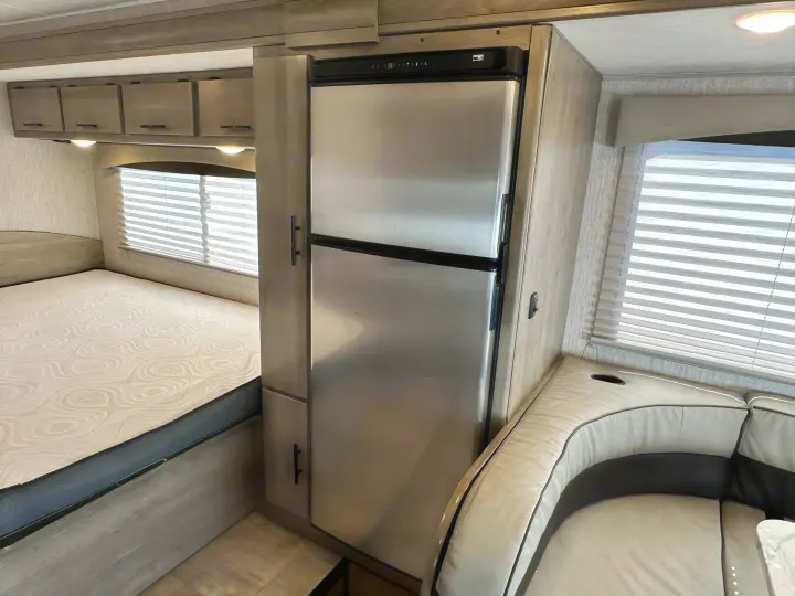 Discover this modern RV rental's spacious interior featuring a comfortable bed, stainless steel refrigerator, ample storage cabinets, and a cozy dinette.. Coachmen Freelander 2022