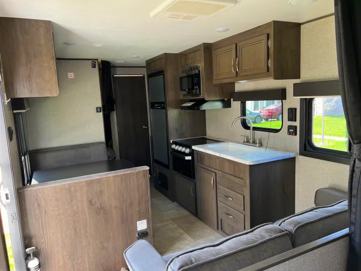 Explore this modern **RV rental**'s spacious interior with a full kitchen, dining booth, and cozy living area.. Jayco Jay Flight SLX 2020