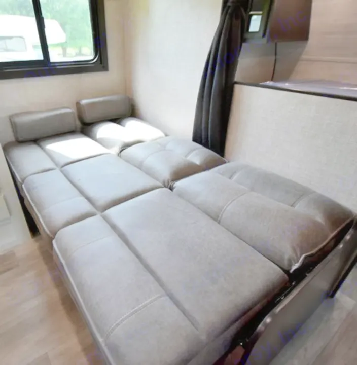 RV rental interior showing a convertible gray sofa bed with headrests, designed for flexible living space.. Jayco Jay Flight SLX 2020