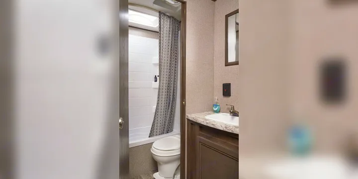 This compact RV rental bathroom features a shower/tub, toilet, and vanity sink, perfect for your next travel adventure.. Jayco Jay Flight SLX 2020