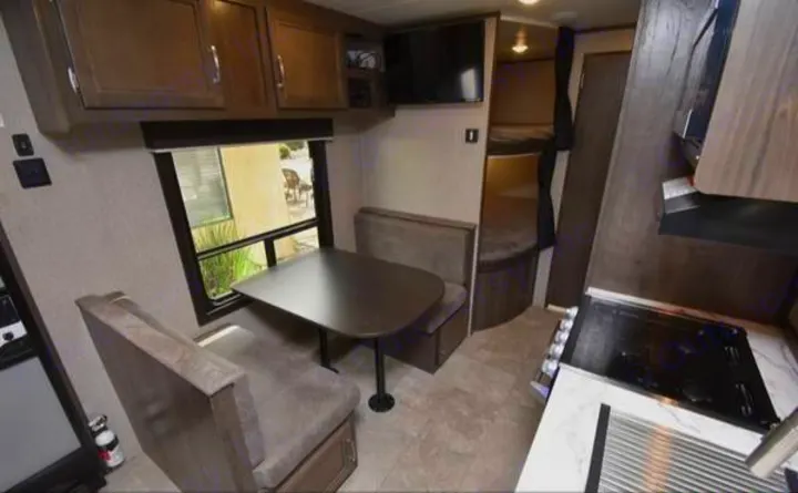 This RV rental interior features a cozy dinette, kitchen, and bunk beds, perfect for family travel adventures.. Jayco Jay Flight SLX 2020