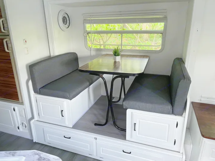 This dinet also turns into a full size bed with extra sheets on the right and outdoor accessories on the left such as outdoor lights basic chairs. Coleman Caravan 2003