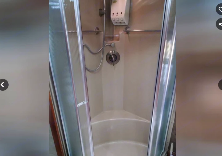 Clean, compact shower stall within an RV, showing a flexible shower head, soap dispenser, and tiered base. Ideal for an RV rental.. Phaeton Phaeton Motorhome 2011