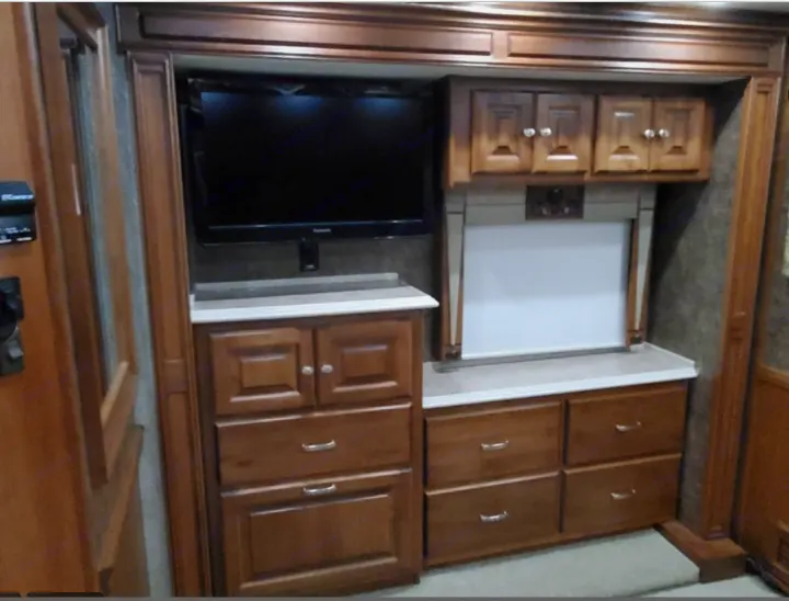 RV rental bedroom interior: TV, overhead & base cabinets, multiple storage drawers. A well-organized space for travel.. Phaeton Phaeton Motorhome 2011