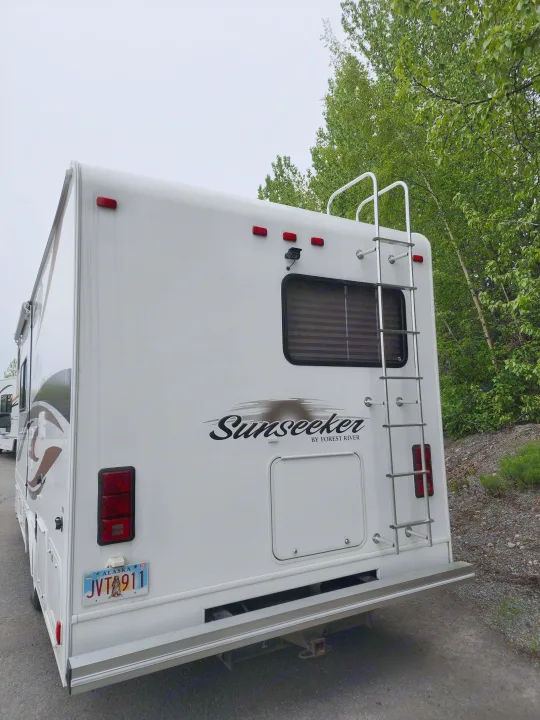 White Sunseeker RV rental rear, featuring a ladder, backup camera, and Alaska license plate.. Forest River Sunseeker 2012