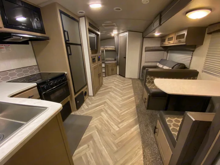 RV rental: comfy interior with kitchen, dining booth, and rear bunk beds.. Shadow Trailers 277BHS 2020