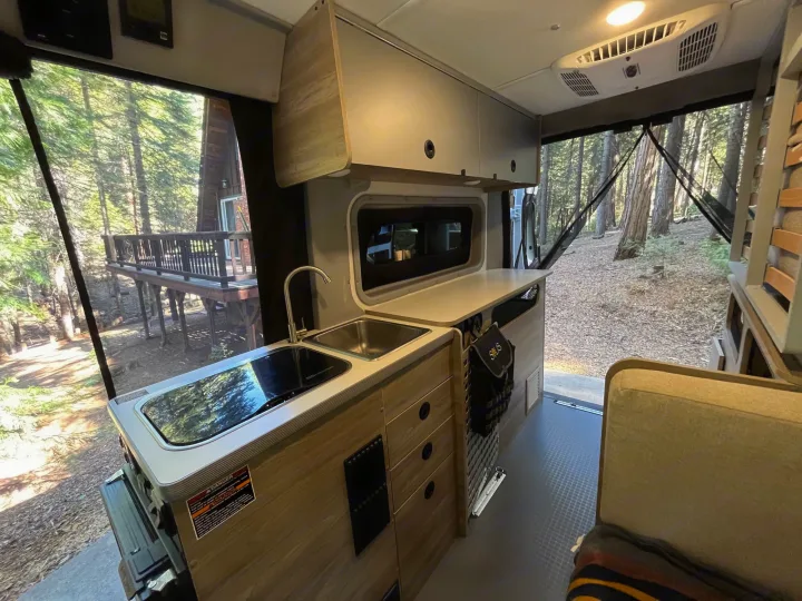 Experience the cozy interior of an RV rental: full kitchen, lounge area, & large screened windows to enjoy nature in this camper van.. Winnebago Solis Pocket 2022