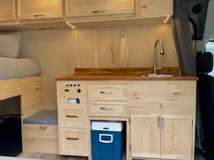 RV rental: Wood camper van interior with kitchen sink, bed, LED lighting, and power outlets.. Ford Transit Custom 2022