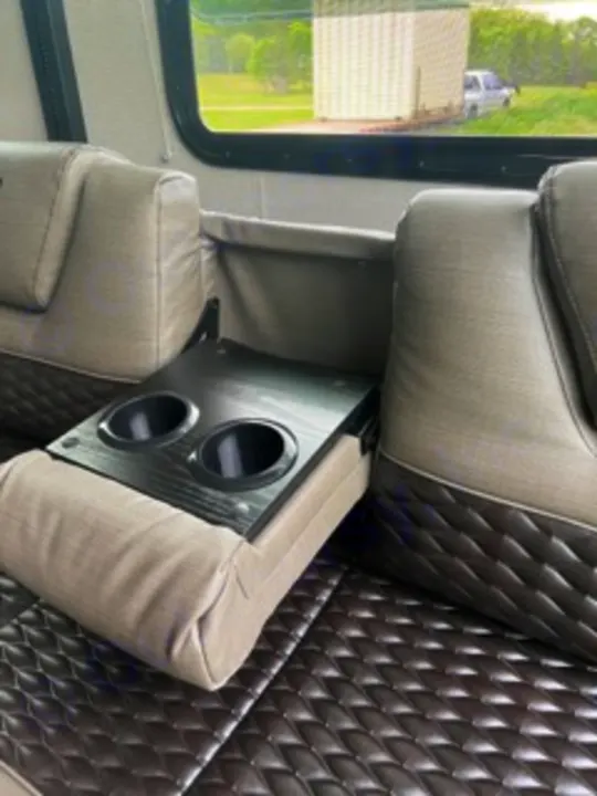 Plush seating in this RV rental offers a fold-down center console with dual cupholders for travel comfort.. Grand Design Momentum 2022