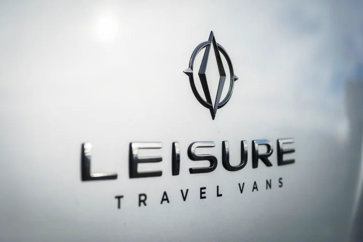 Close-up of a Leisure Travel Vans logo & name on a vehicle, indicating an RV rental option.. Leisure Travel Unity 2017