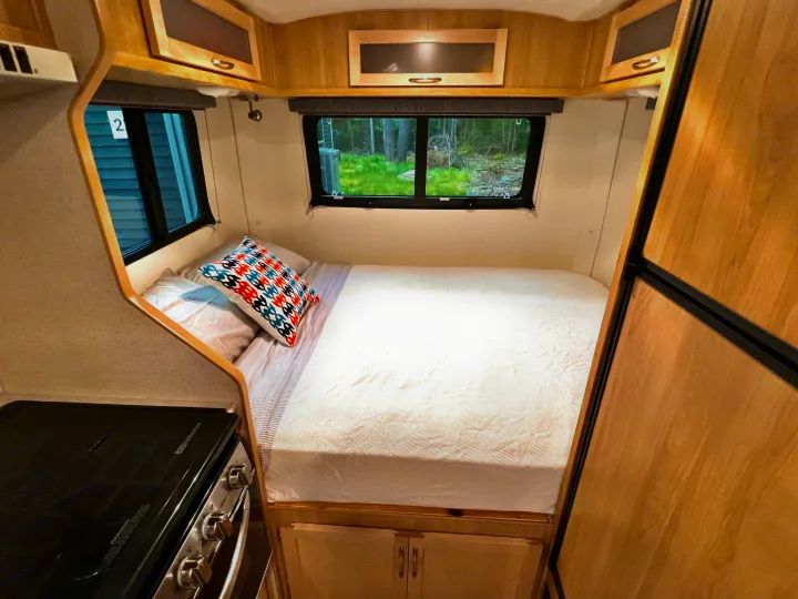 This RV rental showcases a compact interior with a comfortable bed, overhead storage, and a kitchenette, offering scenic views.. Escape Trailer Escape Trailer Trailer 2022