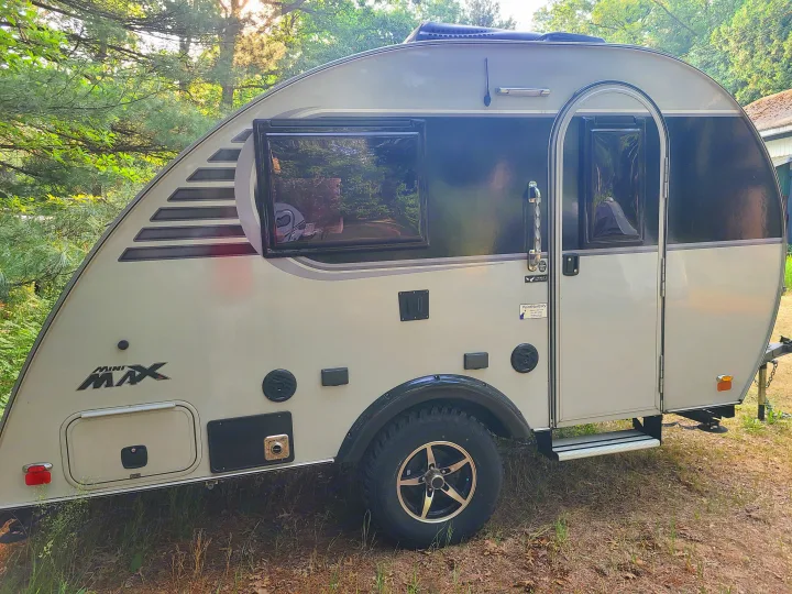 This Mini Max compact travel trailer, perfect for an RV rental, is shown parked outdoors.. Xtreme Outdoors Little Guy 2019