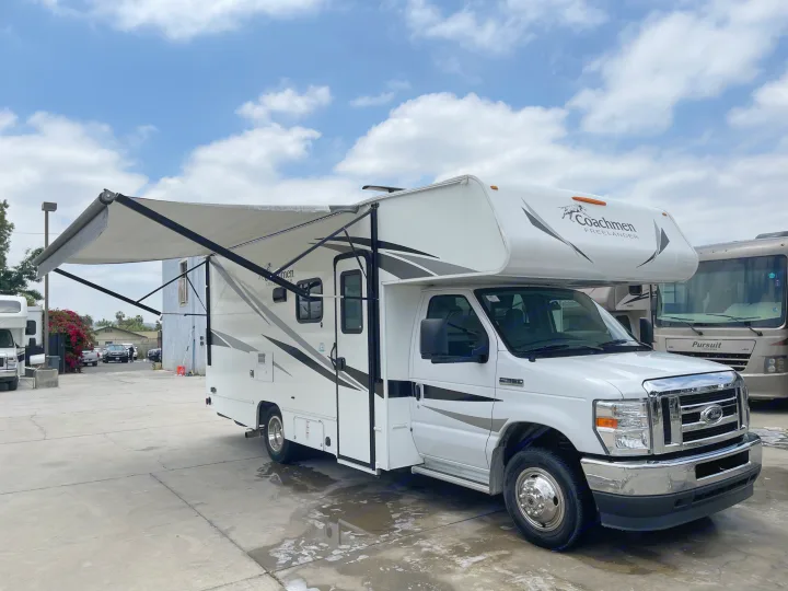 Explore in this white Coachmen Freelander rv rental with an extended awning, parked outdoors. Ideal for travel adventures.. Coachmen Freelander 2021