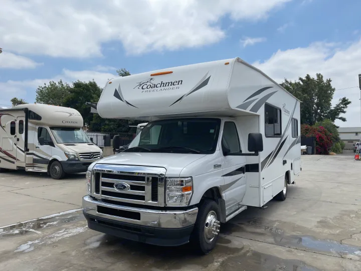 Your next adventure begins with this white Coachmen Freelander Class C rv rental motorhome. A spacious leisure vehicle parked outdoors.. Coachmen Freelander 2021