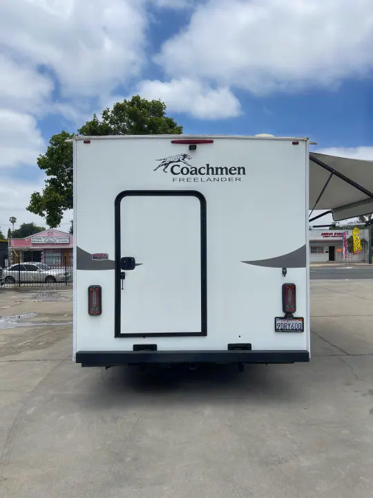 Rear view of a white Coachmen Freelander RV rental, California plate 9DRY600, parked outdoors on concrete.. Coachmen Freelander 2021