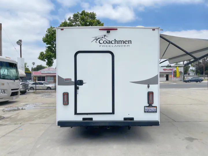 Rear view of a white Coachmen Freelander RV, ideal for your next rv rental. Features a door, tail lights, & CA plate.. Coachmen Freelander 2021