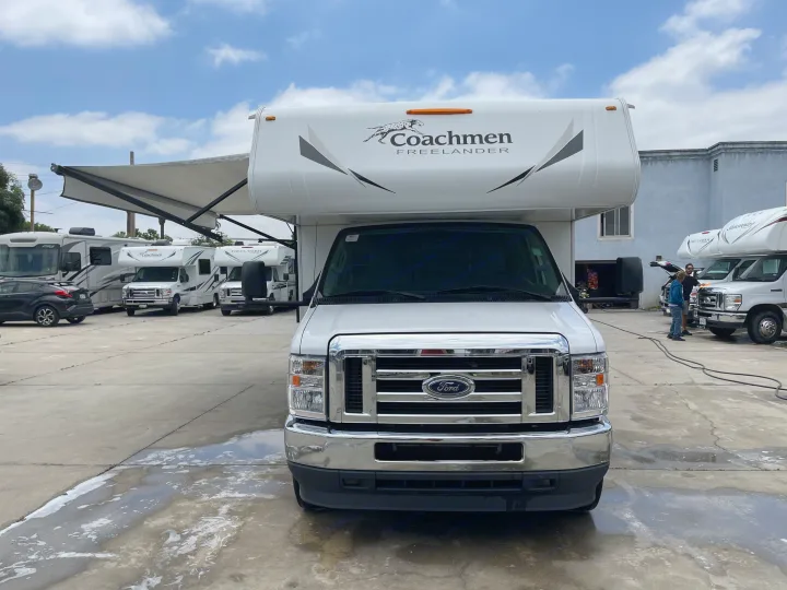 Front view of a white Coachmen Freelander RV at an outdoor rv rental facility, with other motorhomes around.. Coachmen Freelander 2021