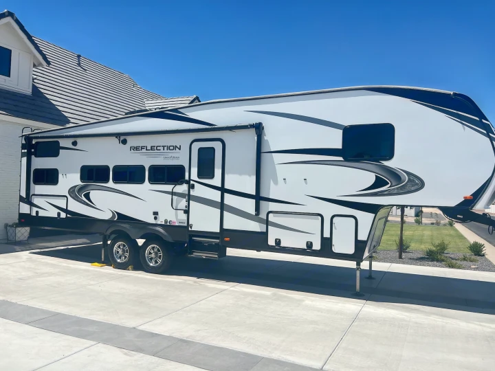 Spacious Reflection fifth-wheel RV, ideal for an rv rental adventure, parked on a sunny driveway. Ready for your next trip!. Grand Design Reflection 2021