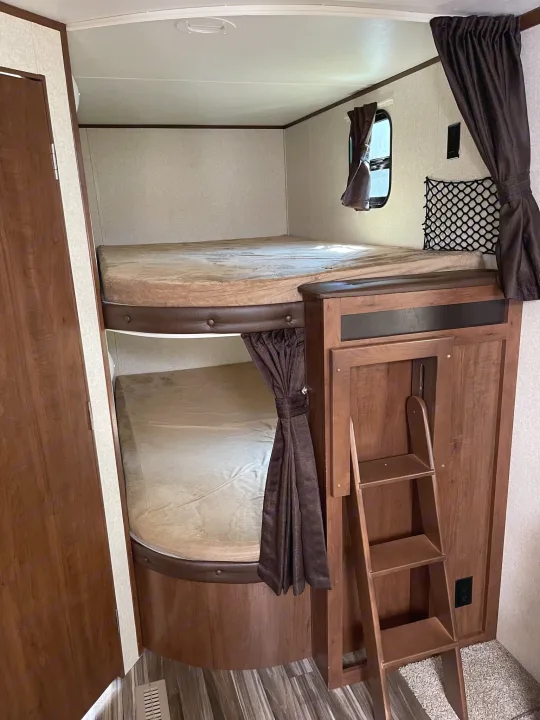 RV rental interior: stacked bunk beds with window, privacy curtains, and a ladder for access.. Jayco Jay Flight 2017