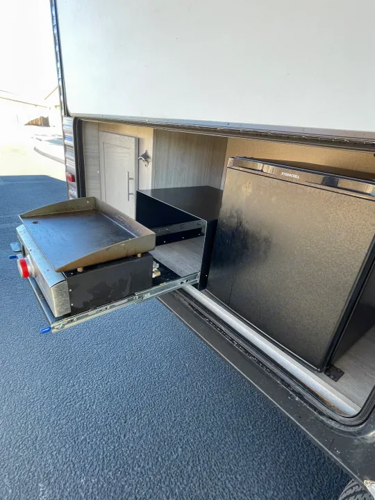 RV rental outdoor kitchen with pull-out griddle, Everchill fridge, and bottle opener for convenient camping.. Coachmen Catalina Summit 2022