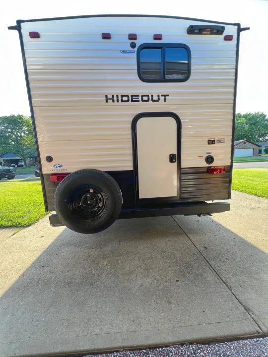 Light-colored Hideout travel trailer parked on concrete, ideal for an RV rental. Ready for your camping adventure!. Hideout 181BH 2023