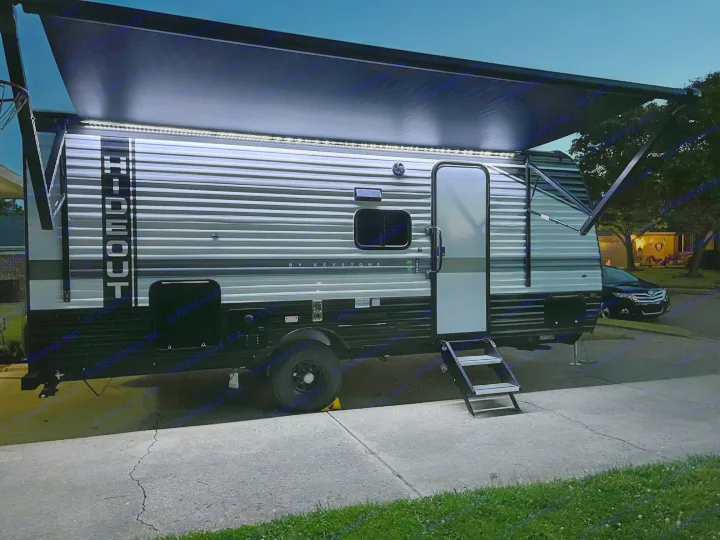 This travel trailer RV rental, with its bright LED awning lights and extended steps, is ready for adventure at night.. Hideout 181BH 2023