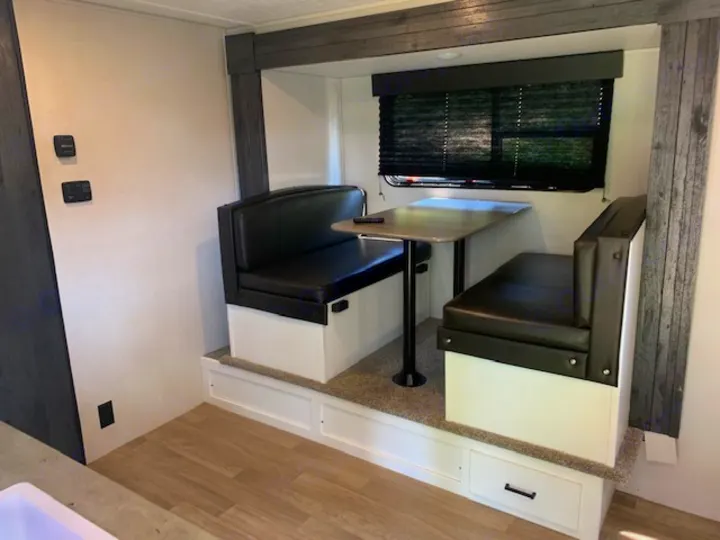 RV rental: Spacious dinette with black benches, a table, window, and storage drawers below.. Keystone RV Hideout 2021