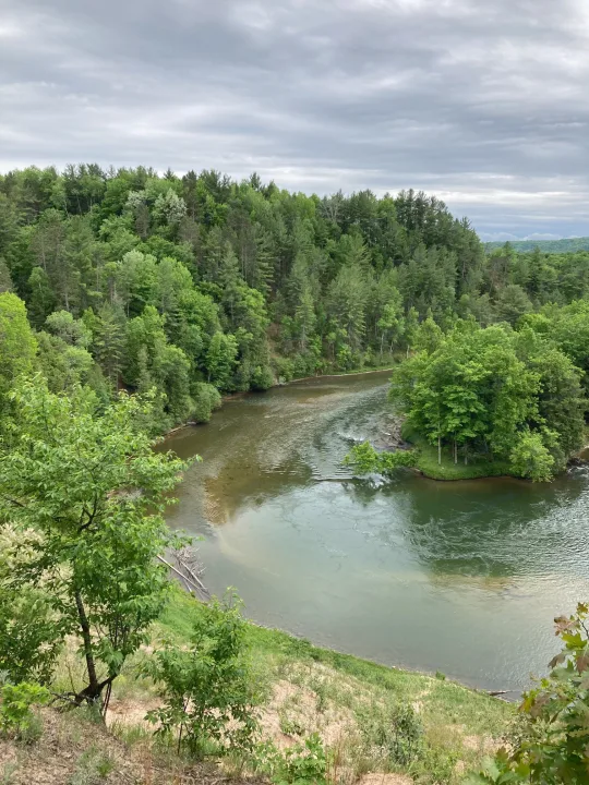 Serene river & lush forest from above, a great spot for an RV rental getaway.. Keystone RV Springdale 2019