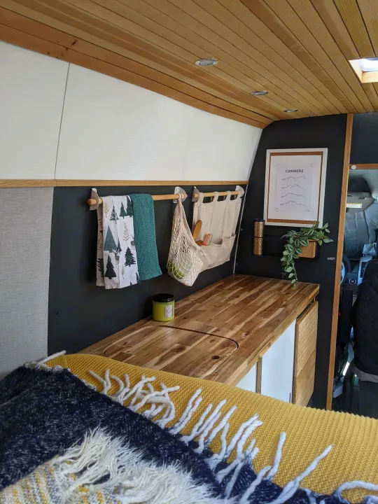 Cozy RV rental interior with modern kitchenette, wood details, and comfortable bed. Perfect for travel.. Mercedes-Benz Mercedes Sprinter 2500 2015