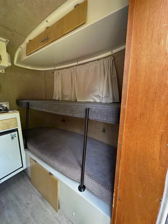 Explore this RV rental: compact interior with bunk beds, a mini-fridge, and overhead storage.. Scamp Scamp Trailer 2010