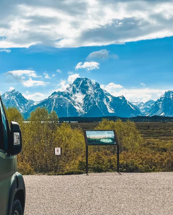 An RV rental offers this Grand Teton NP view: majestic snow-capped mountains over a lush valley, with a wayside exhibit.. Ram Promaster 2020