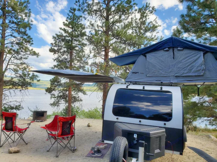 Enjoy lakeside RV rental camping with this teardrop trailer & Thule Tepui rooftop tent setup, complete with chairs & fire pit.. droplet XL 2026