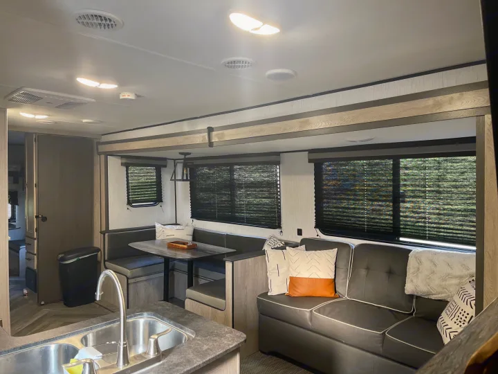 Spacious RV rental interior featuring a modern living area, kitchen sink, and dinette. Bright, comfortable space.. Heartland RVs Prowler 2022