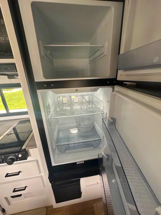 RV rental: Empty, clean refrigerator with freezer and organizing bins inside. Ready for your next road trip!. Keystone RV Hideout 2023